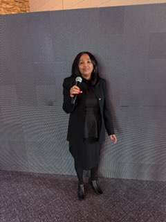 Regina Ross holding a microphone at an event